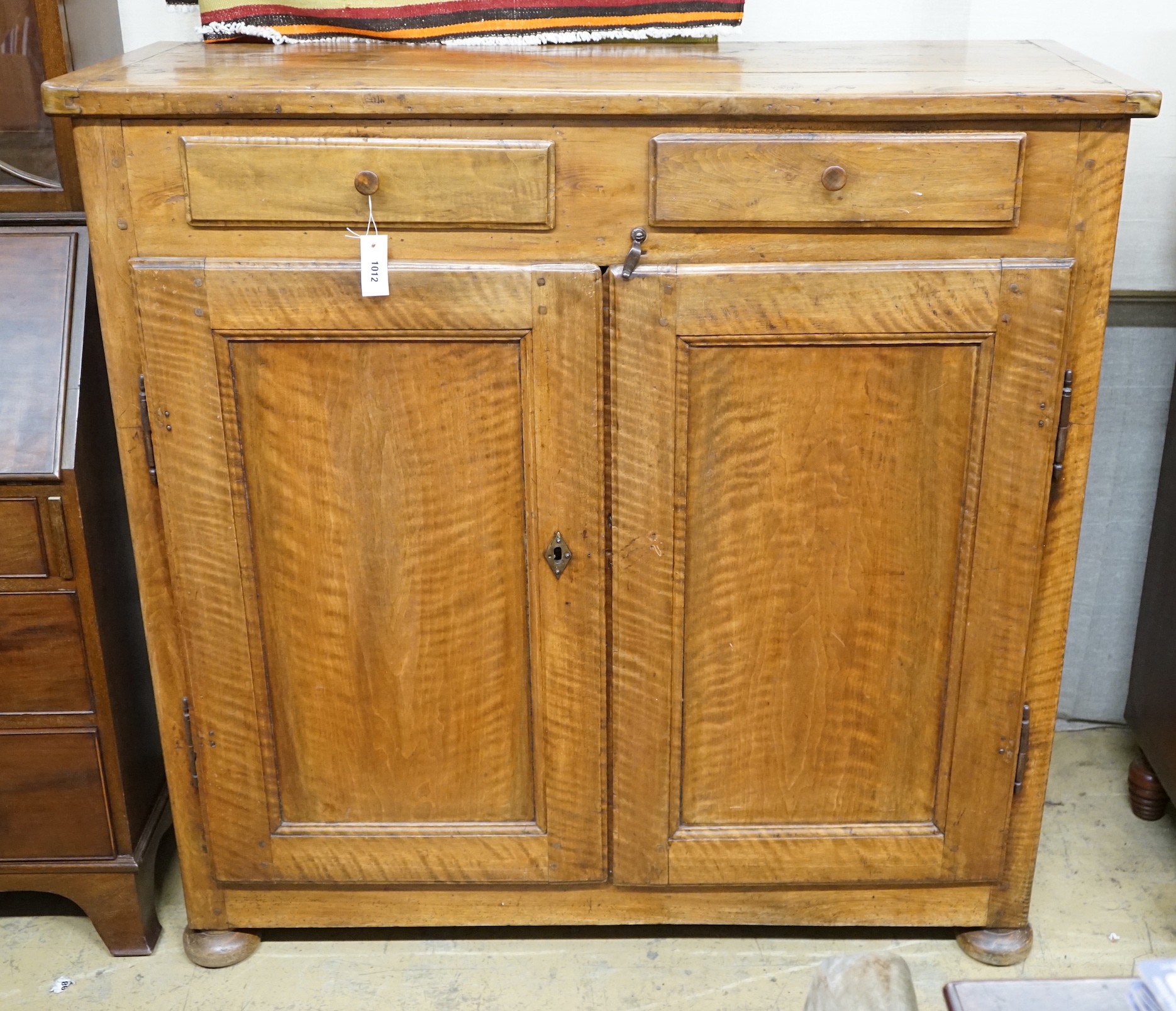 A late18th century continental fruitwood two drawer side cabinet, width 128cm, depth 47cm, height 128cm